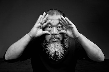 Retrato en blanco y negro de Ai Weiwei con las manos abiertas colocadas alrededor de los ojos