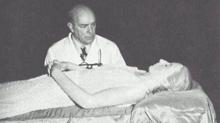 El médico español, Pedro Ara, junto al cuerpo de Eva Perón