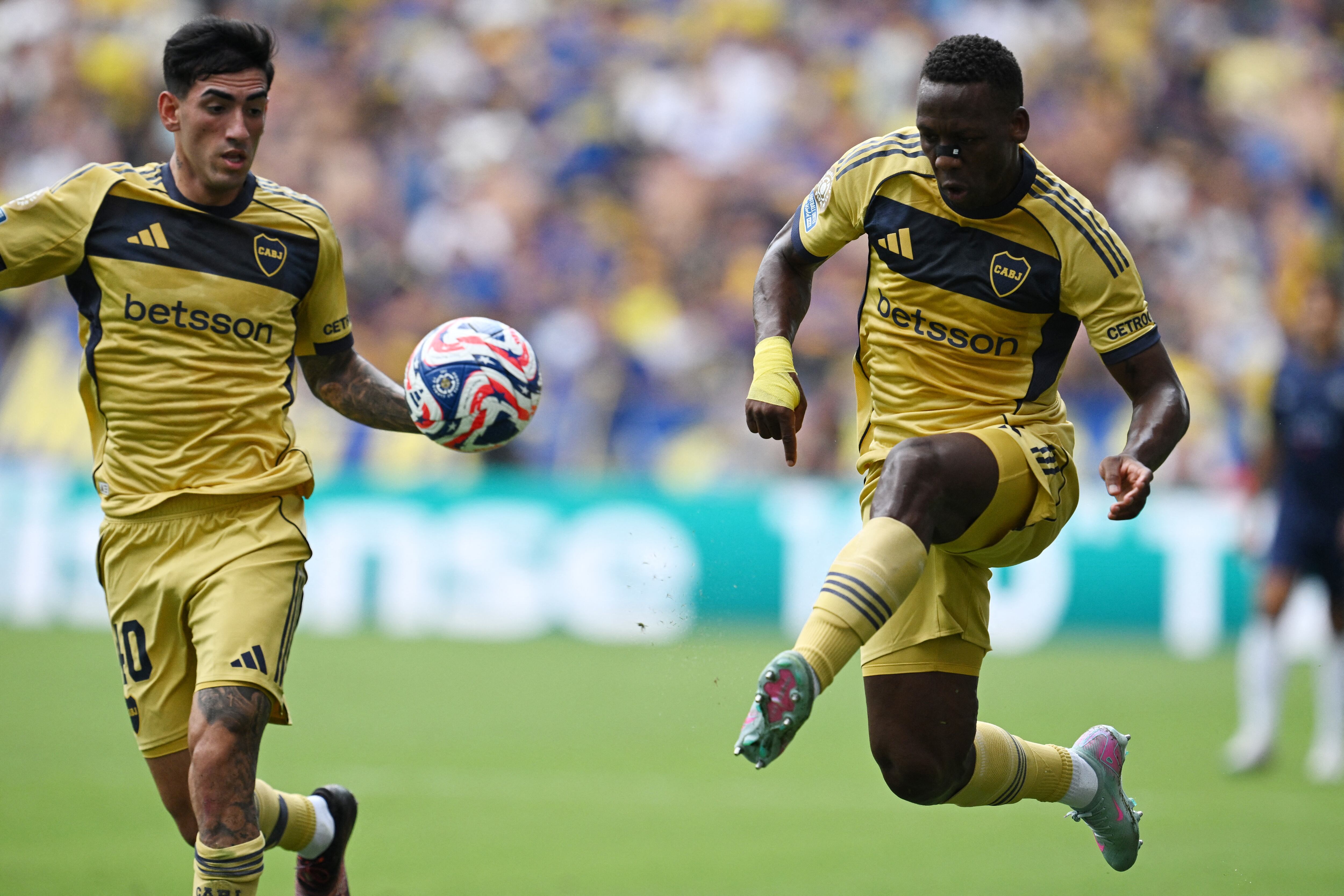 Luis Advíncula rechaza ante la mirada de Lautaro Di Lollo