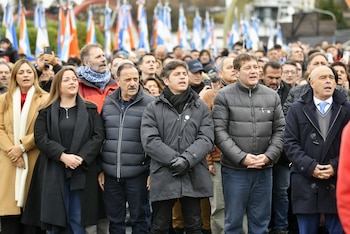 Grupo de personas, incluyendo un veterano de Malvinas con medallas y gorra de la Armada Argentina, y un hombre de chaqueta oscura, parados en un evento al aire libre