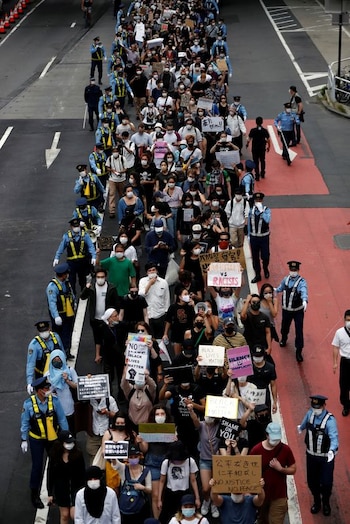 Personas con mascarillas sostienen pancartas durante una marcha en Tokio, Japón. el 6 de junio de 2020. REUTERS/Issei Kato