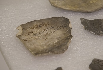 Un fragmento con inscripciones entre los objetos hallados en las excavaciones frente a Notre Dame, París, el 1 de junio de 2026. Las marcas misteriosas pintadas en cerámicas medievales aún no han podido ser descifradas por los expertos. (AP Photo/Nicolas Garriga)