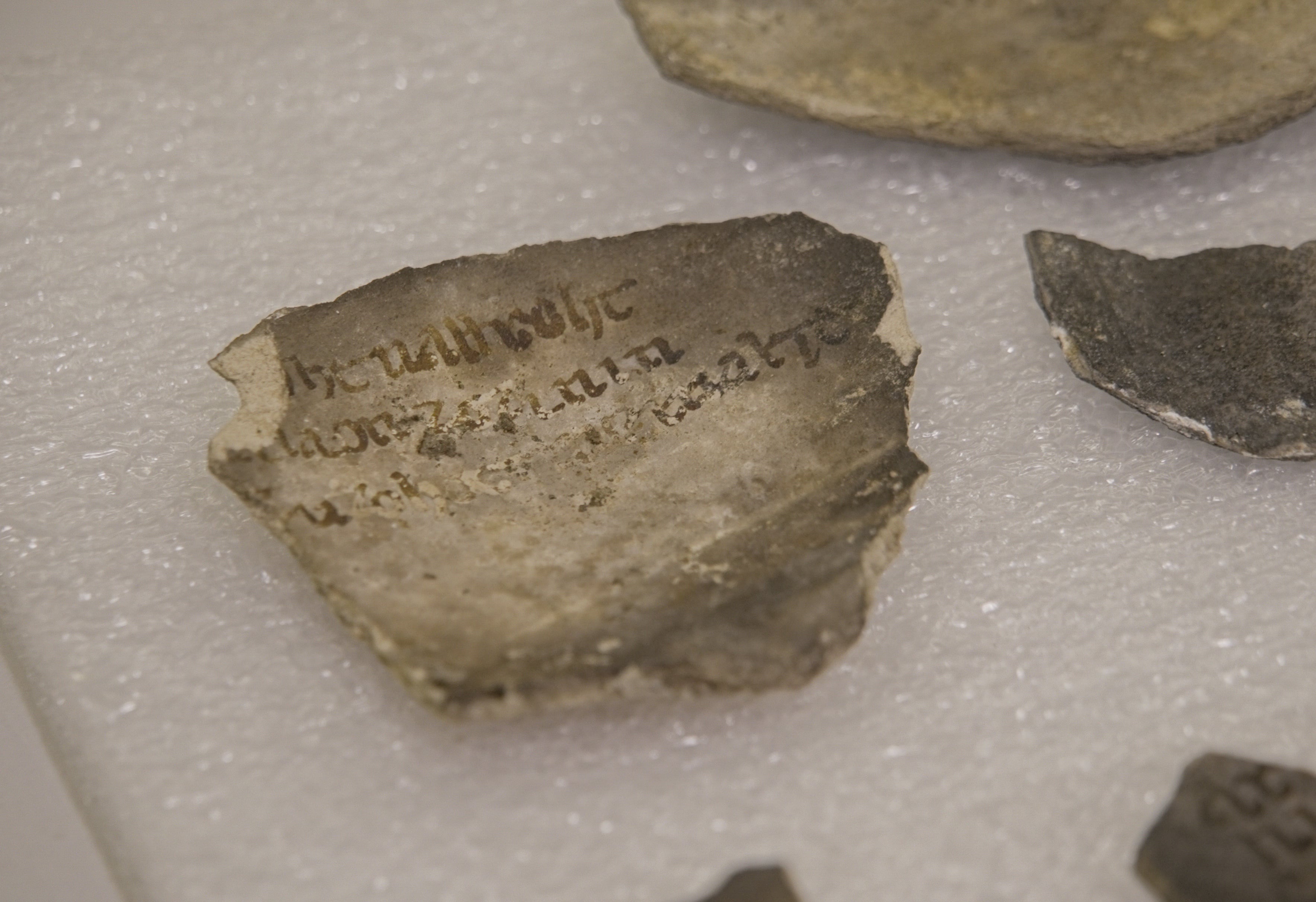Un fragmento con inscripciones entre los objetos hallados en las excavaciones frente a Notre Dame, París, el 1 de junio de 2026. Las marcas misteriosas pintadas en cerámicas medievales aún no han podido ser descifradas por los expertos. (AP Photo/Nicolas Garriga)
