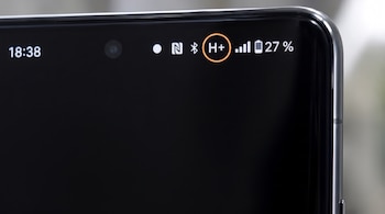 Primer plano de la pantalla de un celular. Muestra la hora 18:38, iconos de NFC, Bluetooth, H+, intensidad de señal, y batería al 27%. H+ está rodeado por un círculo naranja.