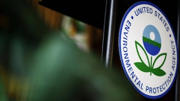 Primer plano del logotipo circular de la Agencia de Protección Ambiental de Estados Unidos (EPA) con texto azul y un diseño central de planta verde y agua azul