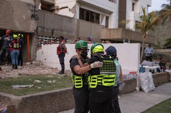 Medina, a la derecha, abrazando a un miembro de su equipo médico frente a su bloque de apartamentos en La Guaira (NYT)