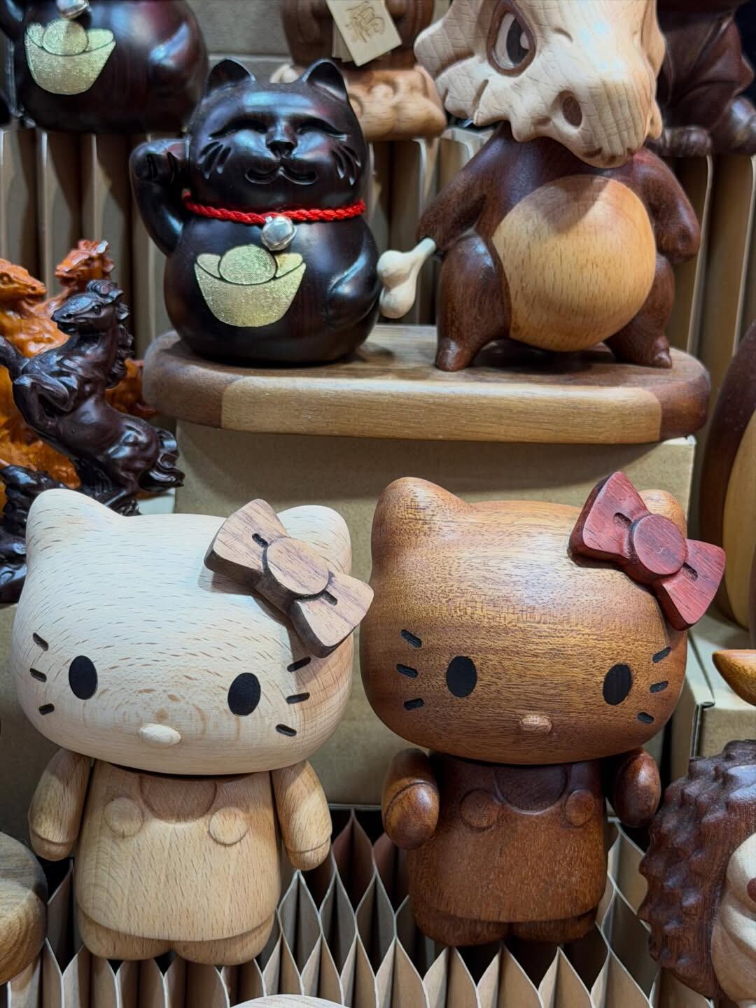Una colección de figuras de madera, incluyendo Hello Kitty, el animé preferido de Wanda, un Maneki-neko y personajes de Pokémon,