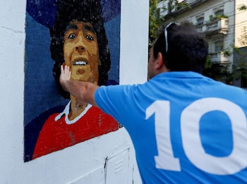 Foto de archivo de un hombre con la camiseta del Napoli tocando un mural en honor a Diego Armado Maradona en Buenos Aires
Feb 25, 2021. REUTERS/Agustin Marcarian/