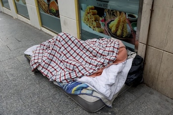 Una persona sin hogar duerme sobre un colchón en una calle de Madrid. (EFE/Mariscal)