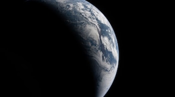 Vista de la curvatura terrestre con masas de nubes y una fina capa verde brillante en el horizonte sobre el fondo del espacio