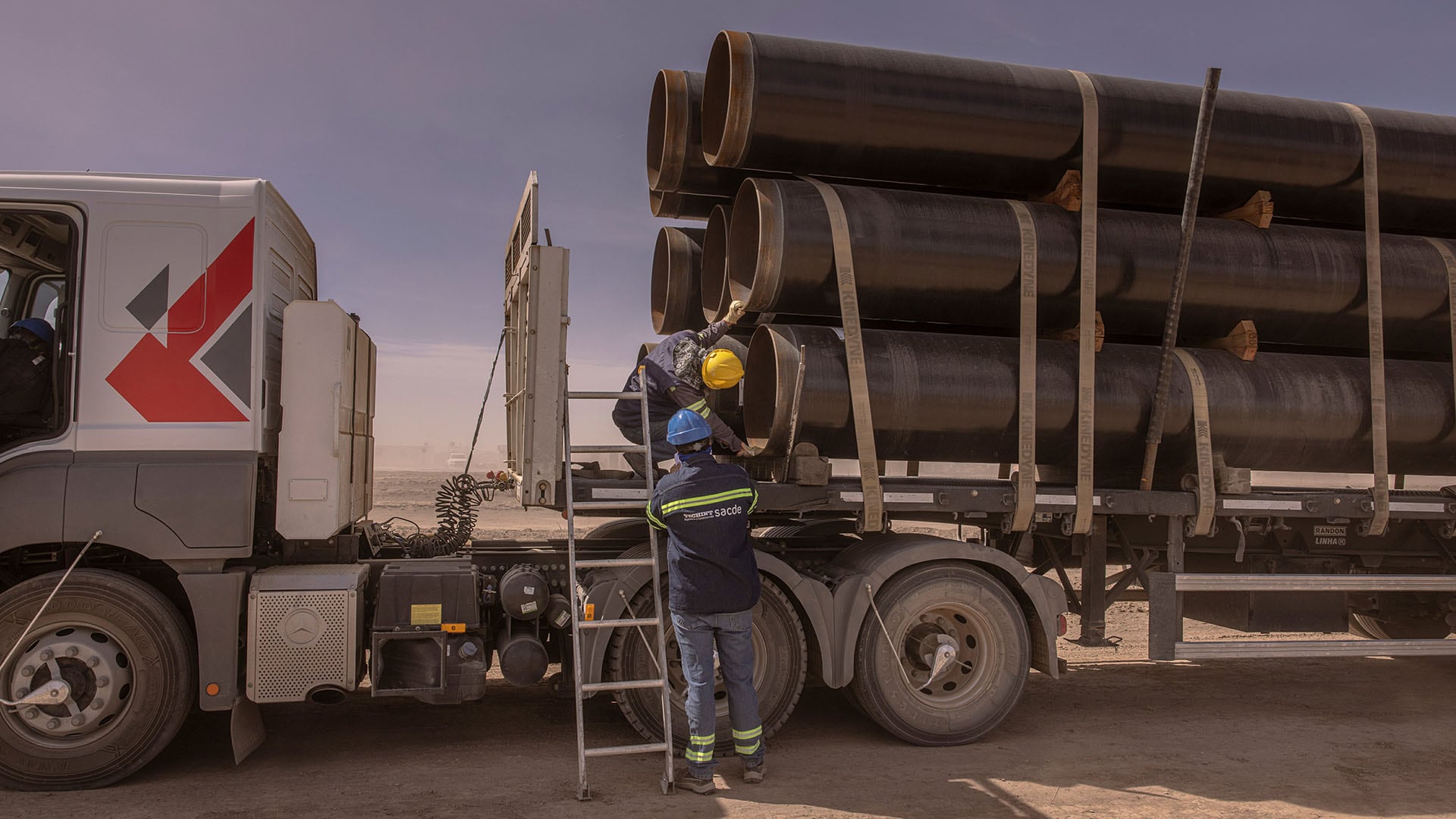 Dos trabajadores inspeccionan tuberías para la industria petrolera de Vaca Muerta