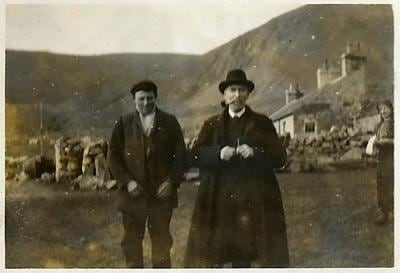 El misionero Dugald Maclean junto a un joven de San Kilda, en abril de 1911. Al fondo, las cabañas de piedra de Village Bay, el único asentamiento permanente en la isla de Hirta