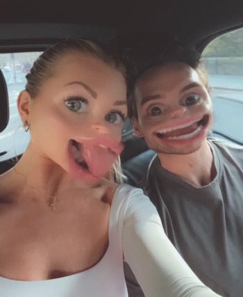 Una mujer y un hombre sonríen dentro de un automóvil mientras un filtro digital distorsiona de forma exagerada los rasgos de sus rostros