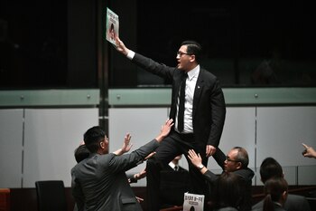 (FILES) In this file photo taken on October 16, 2019, pro-democracy lawmaker Lam Cheuk-ting (C) stands up and protests shortly before Hong Kong's Chief Executive Carrie Lam (not pictured) leaves the chamber for the second time while trying to present her annual policy address at the Legislative Council (Legco) in Hong Kong. - Two prominent Hong Kong opposition lawmakers were arrested early on August 26, 2020 in a police operation focused on last year's huge anti-government protests, the latest move in a widening crackdown against the city's democracy camp. (Photo by ANTHONY WALLACE / AFP)
