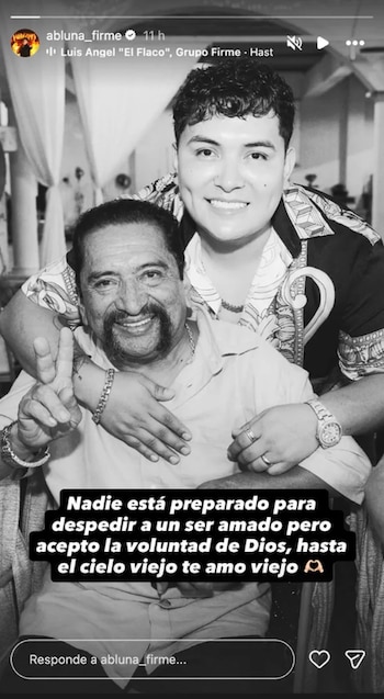 Fotografía en blanco y negro de Abraham Luna sonriente, abrazando a su padre, quien sonríe y hace el signo de la paz
