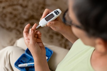 Una paciente de diabetes se mide los niveles de azúcar en sangre (Magnific)