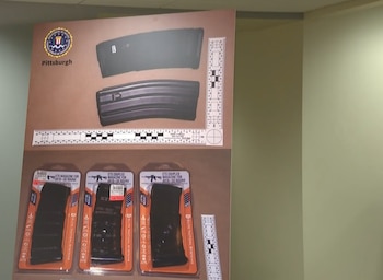 Un cartel con el sello del FBI de Pittsburgh muestra cargadores de armas de fuego y paquetes comerciales con escalas de medición