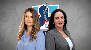 Dos mujeres, una con cabello claro y camisa azul, la otra con cabello oscuro y blazer gris. Detrás de ellas, un logo azul y blanco del Centro Democrático fragmentado.