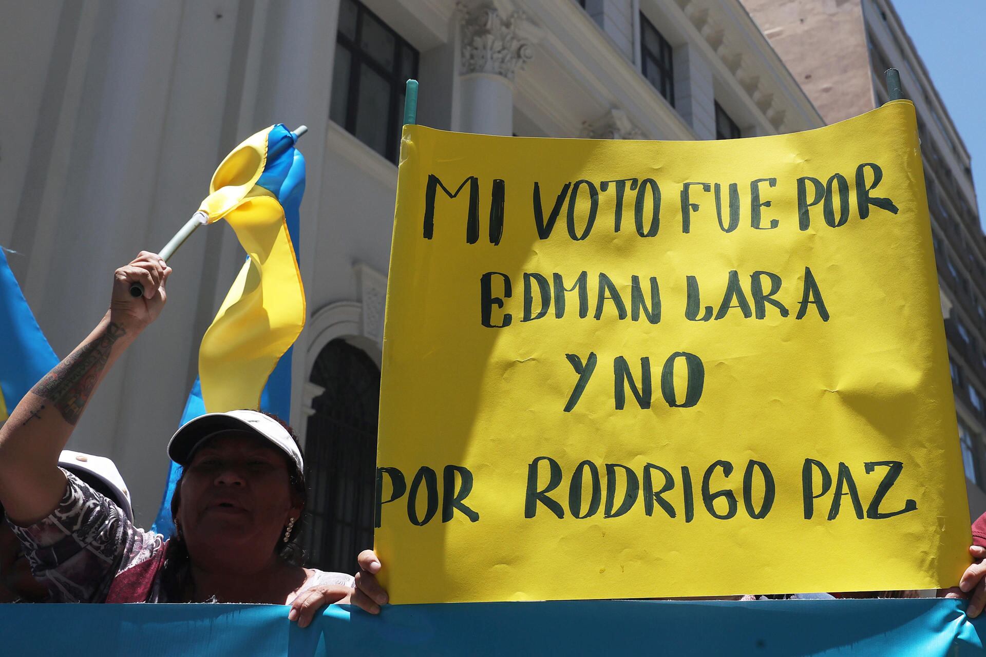 Personas sostienen carteles y banderas en apoyo al vicepresidente de Bolivia, Edmand Lara, durante una protesta afuera de la vicepresidencia este viernes, en La Paz (EFE/ Luis Gandarillas)