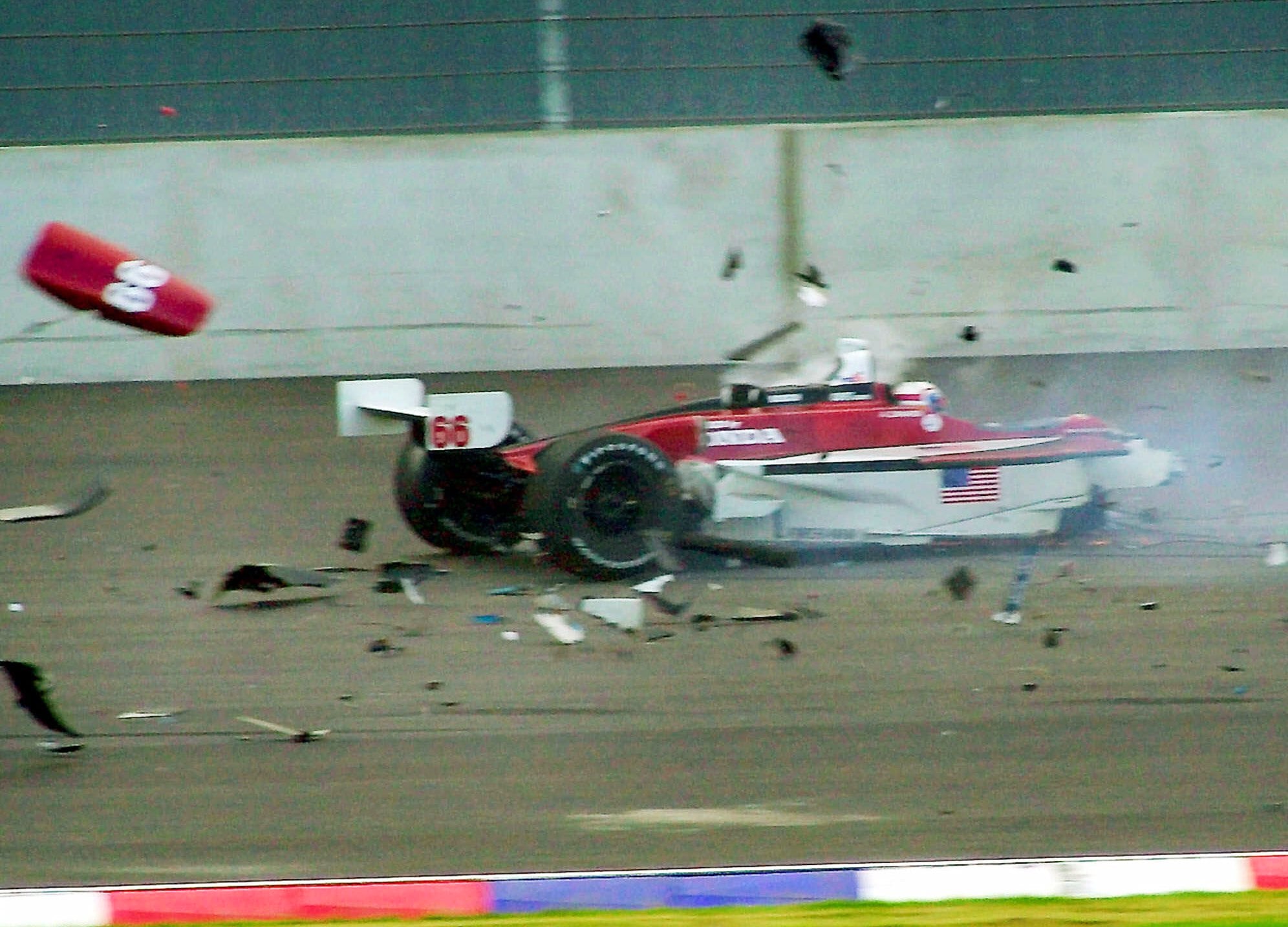 El coche del piloto italiano se desintegra tras chocar con el del piloto canadiense Alex Tagliani durante la carrera de la CART en el circuito Eurospeedway Lausitz en Klettwitz, al este de Alemania, el sábado 15 de septiembre de 2001 (AP Photo/Eckehard Schulz)