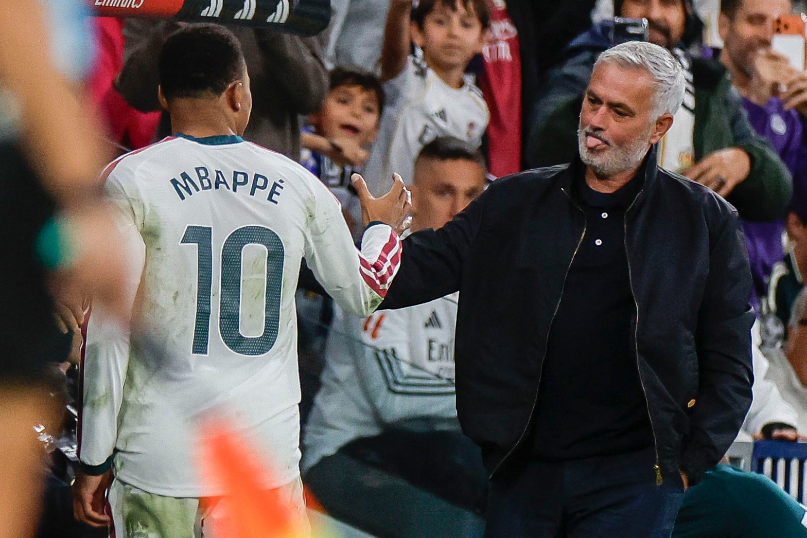 El delantero francés del Real Madrid Kylian Mbappé saluda a José Mourinho tras su cambio durante el partido de la jornada 9 de LaLiga entre el Real Madrid y el Sevilla FC, este domingo en el estadio Santiago Bernabéu. EFE/Javier Lizón
