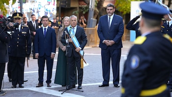 Alfredo Cornejo, con traje y banda celeste y blanca, habla en micrófono al aire libre. Lo rodean funcionarios y policías. Sostiene un bastón de mando