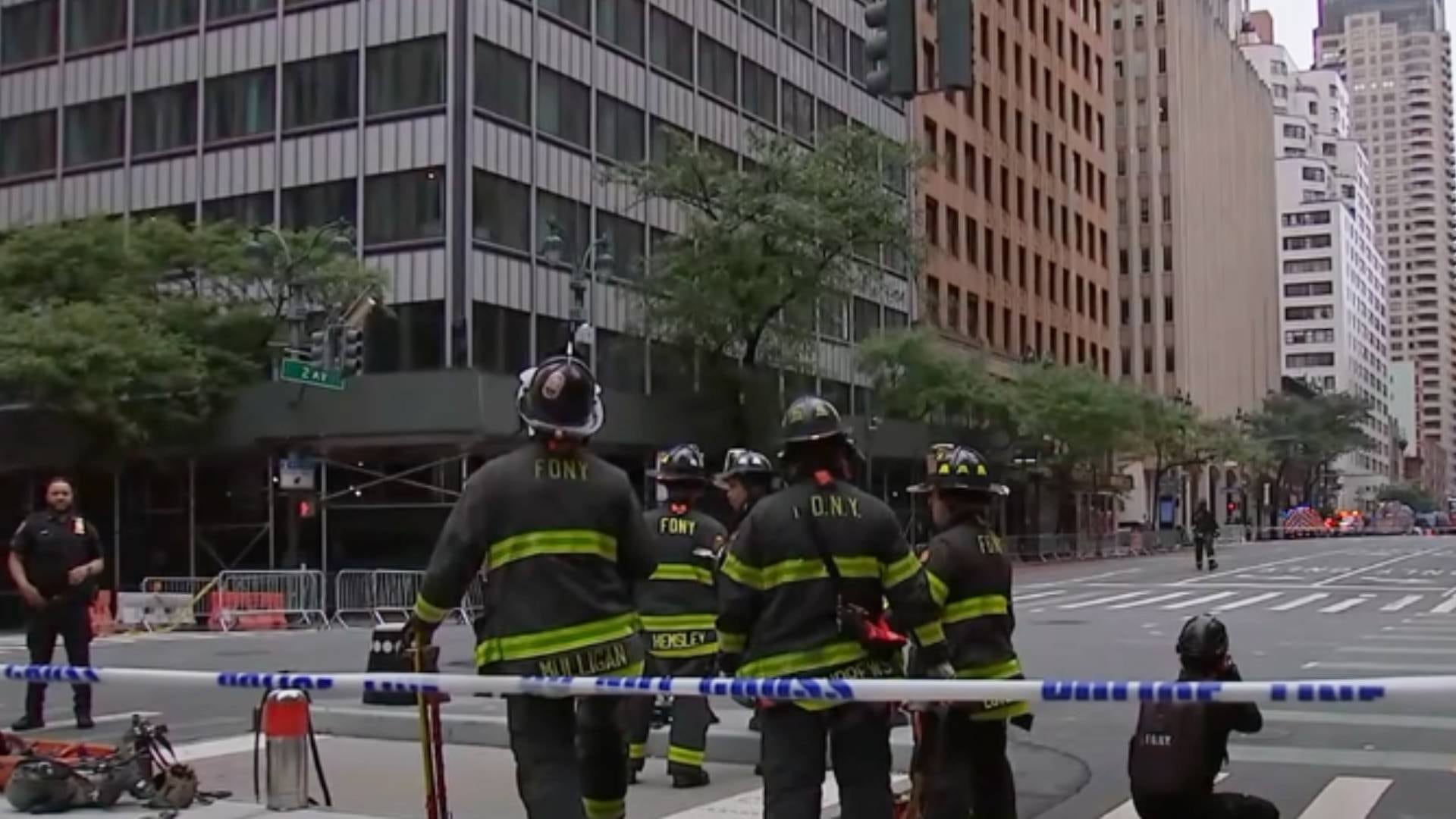 Bomberos del FDNY y un oficial de policía resguardan la Segunda Avenida de Nueva York, con una cinta policial que cruza la calle y edificios altos de fondo (ABC7)