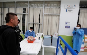 Personal médico toma la temperatura de los ciudadanos que cruzan la frontera por el puente Rumichaca, que une Ecuador y Colombia (REUTERS/Daniel Tapia)