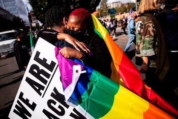 Una pareja abrazada con la bandera que idenfitica a la comunidad LGTBQ fue registrada este sábado al festejar el triunfo del demócrata Joe Biden en las elecciones presidenciales estadounidenses, en Los Ángeles (California, EE.UU.). EFE/Etienne Laurent