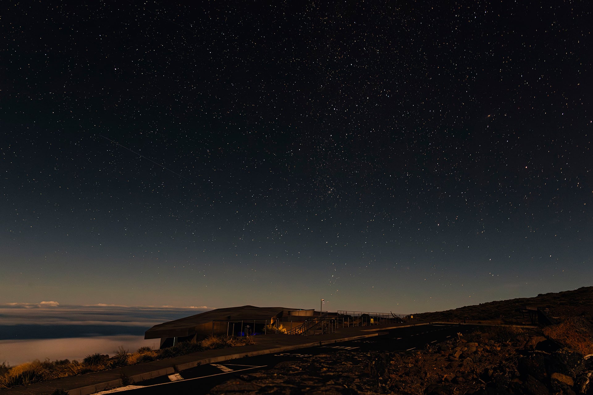 Un cielo despejado cubierto de estrellas se extiende sobre el centro de visitantes del Roque de los Muchachos y un mar de nubes en la isla de La Palma. (Pexels)
