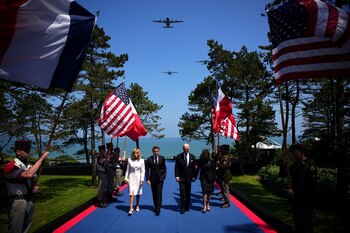 El Presidente Joe Biden y la Primera Dama Jill Biden llegan con el Presidente francés Emmanuel Macron, y su esposa Brigitte Macron llegan a la conmemoración (Daniel Cole/REUTERS)