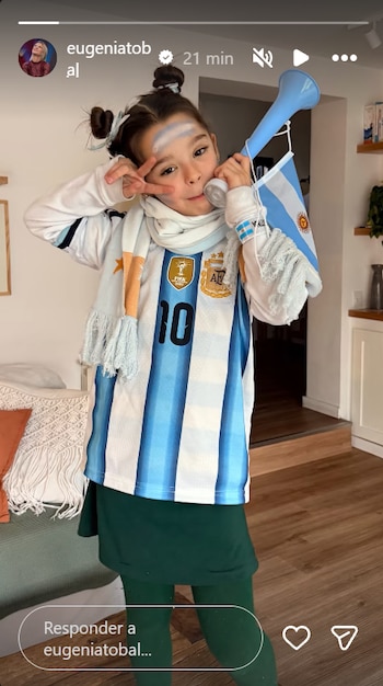 Niña con camiseta número 10 de la Selección Argentina, bufanda, pintura facial, vuvuzela, bandera argentina y dos rodetes