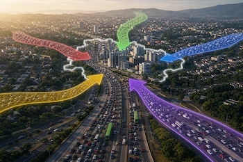 Fotografía aérea de autopistas con tráfico denso y flechas luminosas de colores dirigidas hacia el centro de una ciudad.