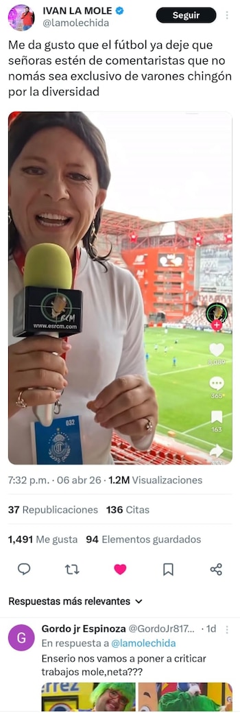 La Mole, maquillado y con cabello largo, sostiene un micrófono frente a un estadio de fútbol con gradas rojas y el campo verde visible al fondo