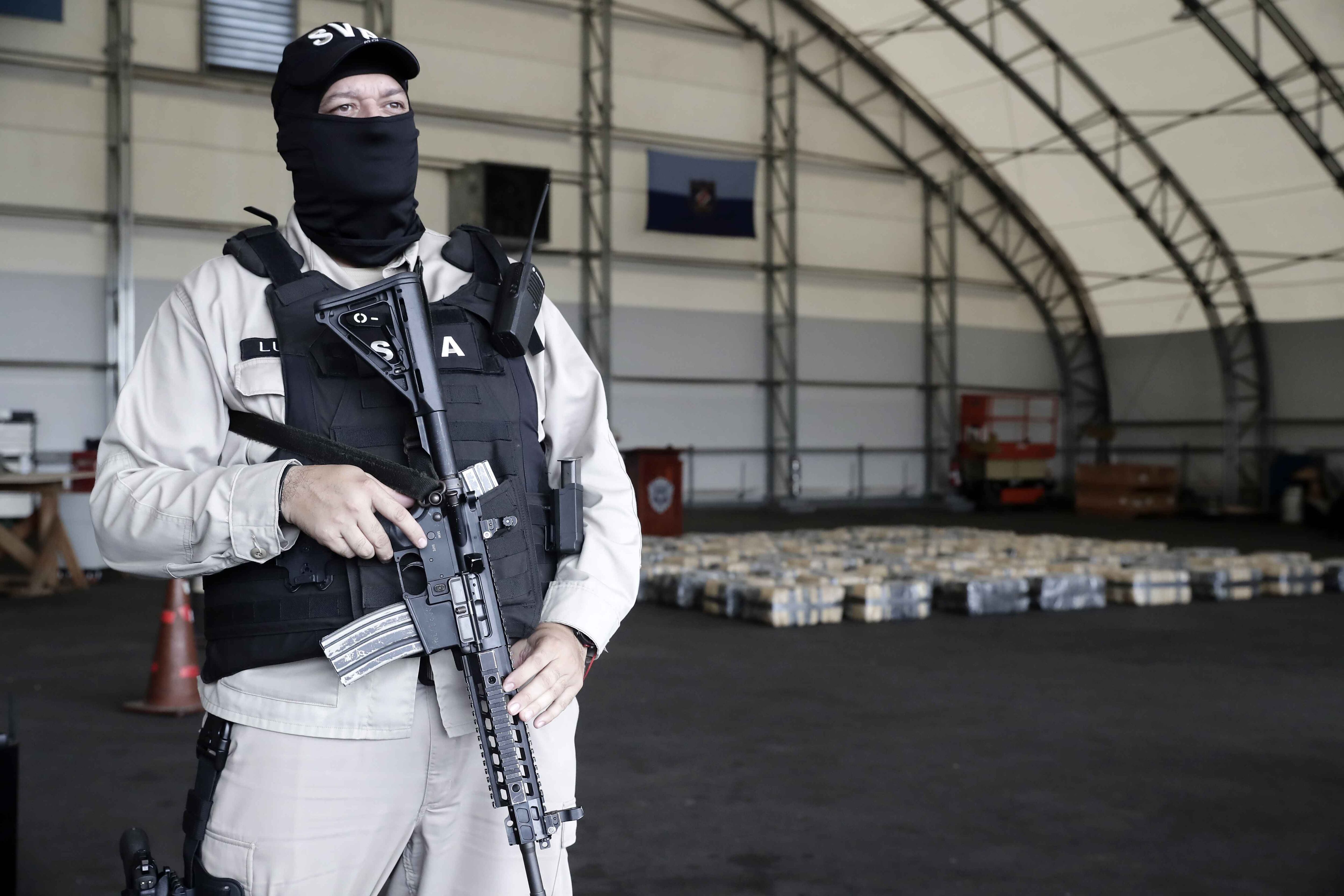 Policías vigilan 2.024 kilos de marihuana y 485 kilos de cocaína decomisados y que eran transportados en una lancha tripulada por dos costarricenses y un nicaragüense en San José (Costa Rica). EFE/ Jeffrey Arguedas