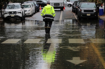 Un hombre permanece de pie en una calle inundada mientras fuertes lluvias llegan al noreste de Estados Unidos, en Hoboken, Nueva Jersey, EE.UU., el 26 de octubre de 2021. (REUTERS/Mike Segar)