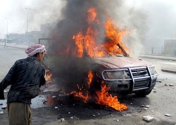 Un iraquí observa una camioneta en llamas tras un ataque de insurgentes en Falluja en 2004. (REUTERS/Salman Amer/archivo)