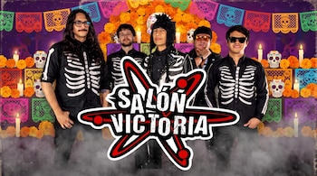 Cinco hombres vestidos de negro con estampados de huesos posan ante una pared con papel picado, calaveras y el logotipo de Salón Victoria.