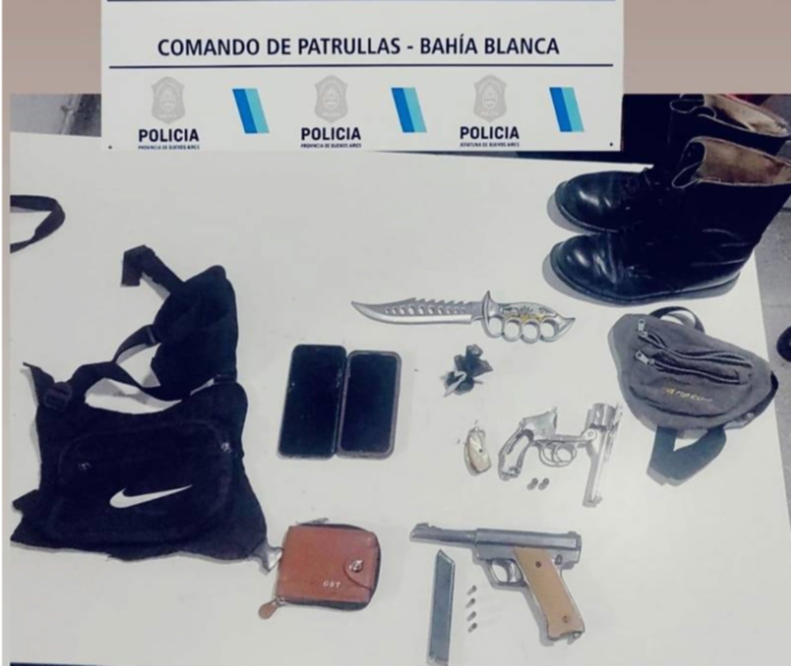 El Comando de Patrullas de Bahía Blanca exhibe armas de fuego, un cuchillo y teléfonos celulares secuestrados durante un procedimiento policial. (La Nueva)