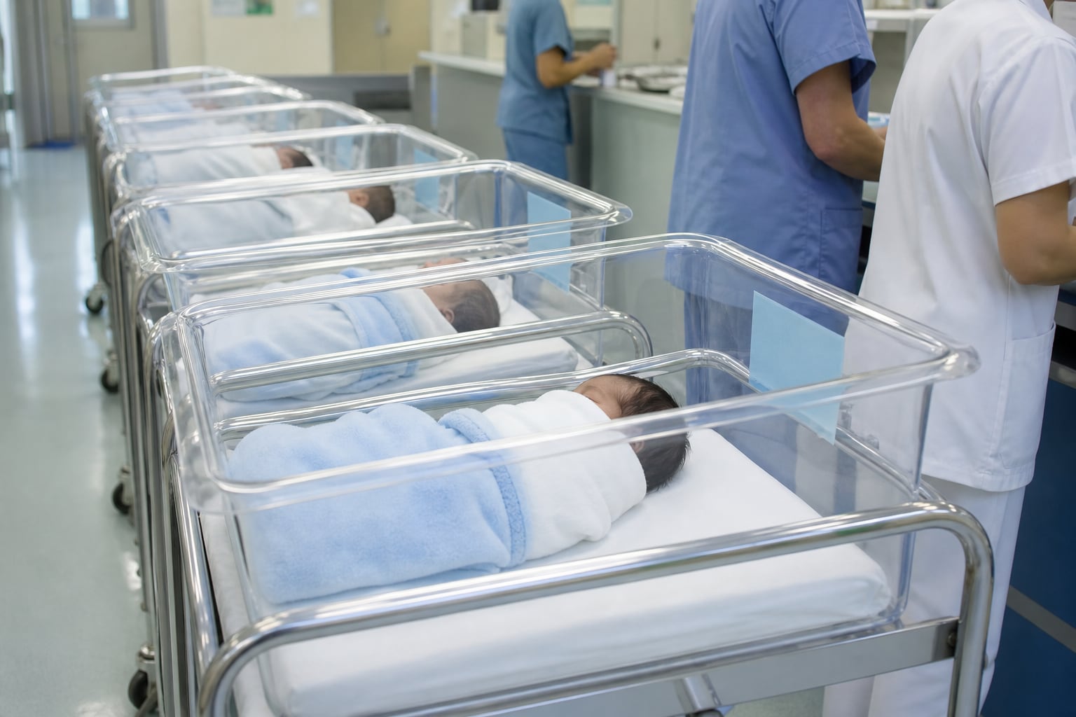 Varios recién nacidos permanecen en cunas transparentes dentro de una sala de maternidad mientras el personal de enfermería atiende el área. (Imagen Ilustrativa Infobae)