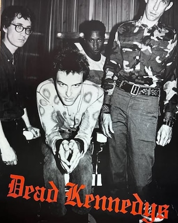 Fotografía en blanco y negro de cuatro hombres y el texto en letras rojas "Dead Kennedys" en la parte inferior