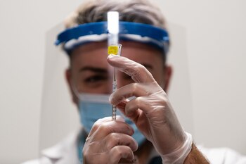 A pharmacist draws a dose