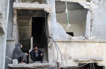 FOTO DE ARCHIVO: Palestinos sentados sobre los escombros de su casa destruida por los ataques aéreos israelíes durante los combates entre israelíes y palestinos, en Gaza, 9 de junio de 2021. REUTERS/Mohammed Salem