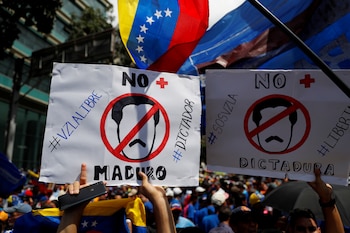 La gente sostiene pancartas que