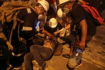 Un manifestante es auxiliado por