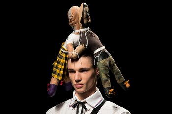 Dos muñecos sobre la cabeza del modelo en la pasada de Brain & Beast en Madrid Fashion Week, una de las más innovadoras y vanguardistas de la semanas de la moda internacional