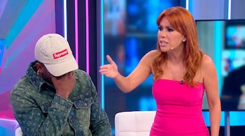 Magaly Medina, con cabello rojizo y vestido fucsia, gesticula enérgicamente frente a un hombre con gorra blanca y chaqueta de mezclilla que cubre su rostro.
