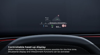 Proyección digital en un parabrisas con datos de velocidad, navegación e iconos de tráfico, situada sobre el borde de un volante