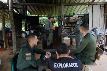 ALTO LIMÓN (PANAMÁ), 14/08/2026.- Agentes de la Policía Nacional de Colombia y del Servicio Nacional de Fronteras de Panamá (Senafront) dialogan en la base Binacional Alto Limón en la selva del Tapón del Darién este viernes, línea fronteriza entre Panamá y Colombia, Alto Limón (Panamá). Cerca del Puesto Binacional, se extienden unas 500 hectáreas de siembra de coca en territorio de Colombia. Militares colombianos trabajan en su erradicación mientras policías de Panamá los resguardan frente a un eventual ataque de grupos armados. EFE/ Bienvenido Velasco