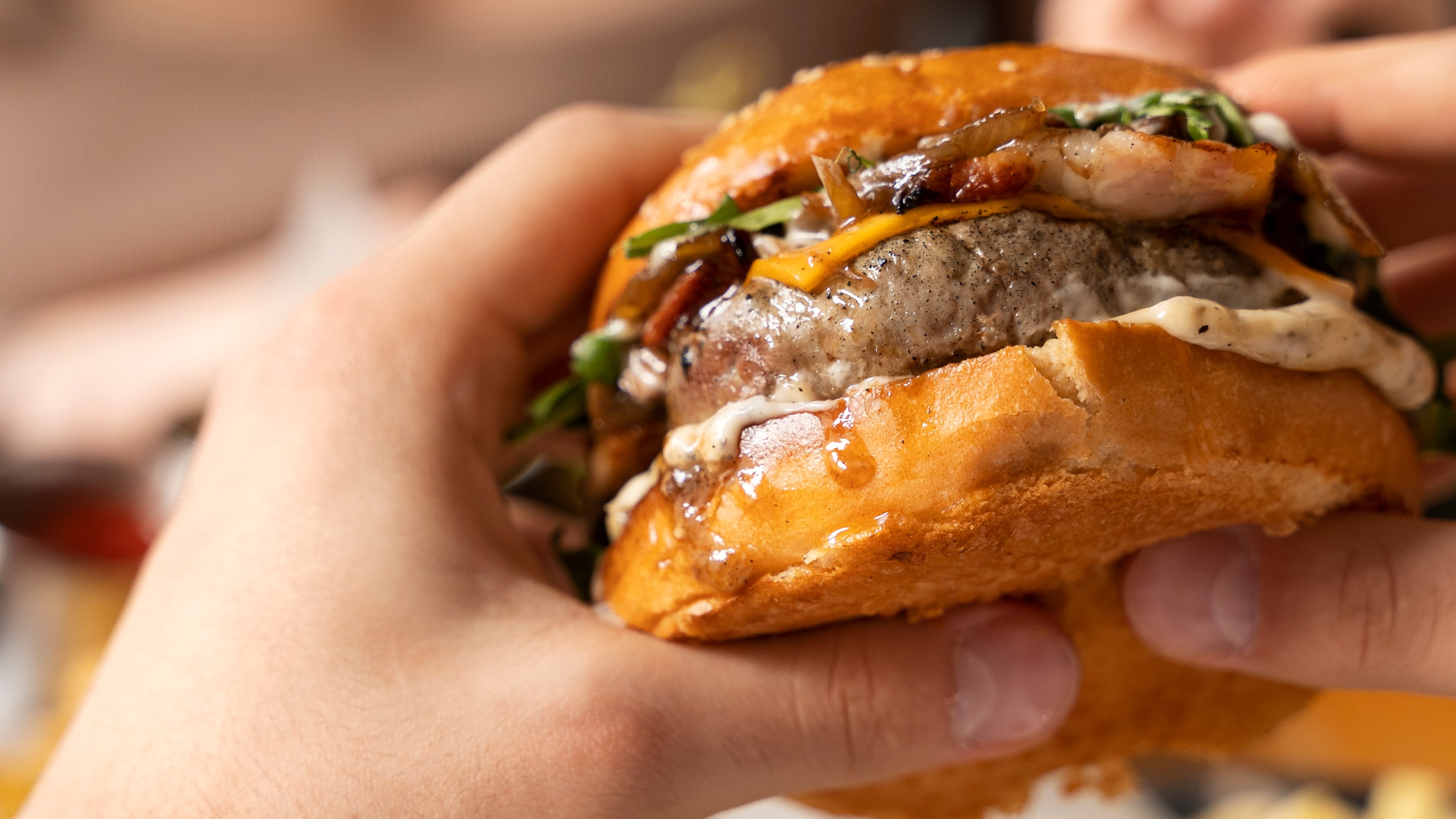 Un hombre comiendo una hamburguesa (Freepik)